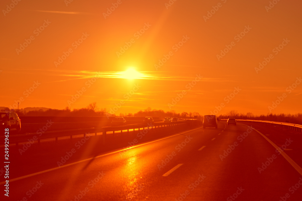 Straße bei Sonnenuntergang und mässigen Verkehr