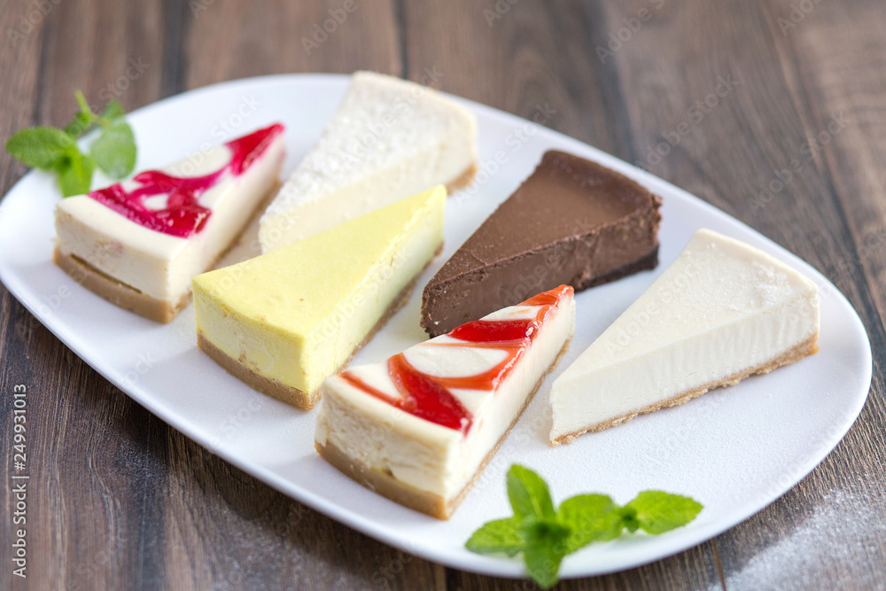 Slices of various cheese cakes on white plate. Sugar desserts, food concept Slices of various cheese cakes on white plate. Sugar desserts, food concept
