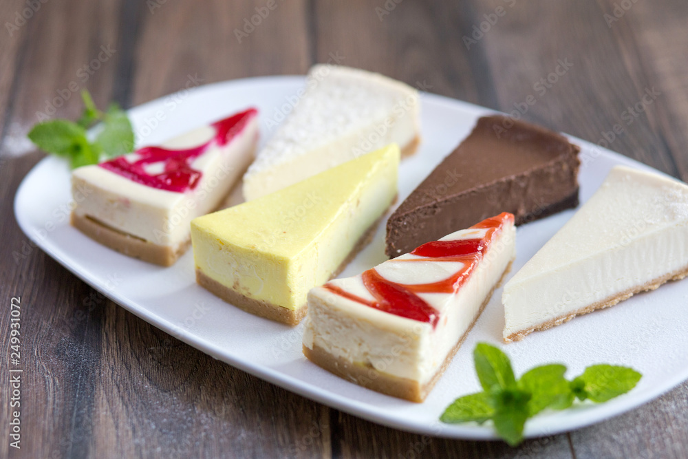 Slices of various cheese cakes on white plate. Sugar desserts, food concept 