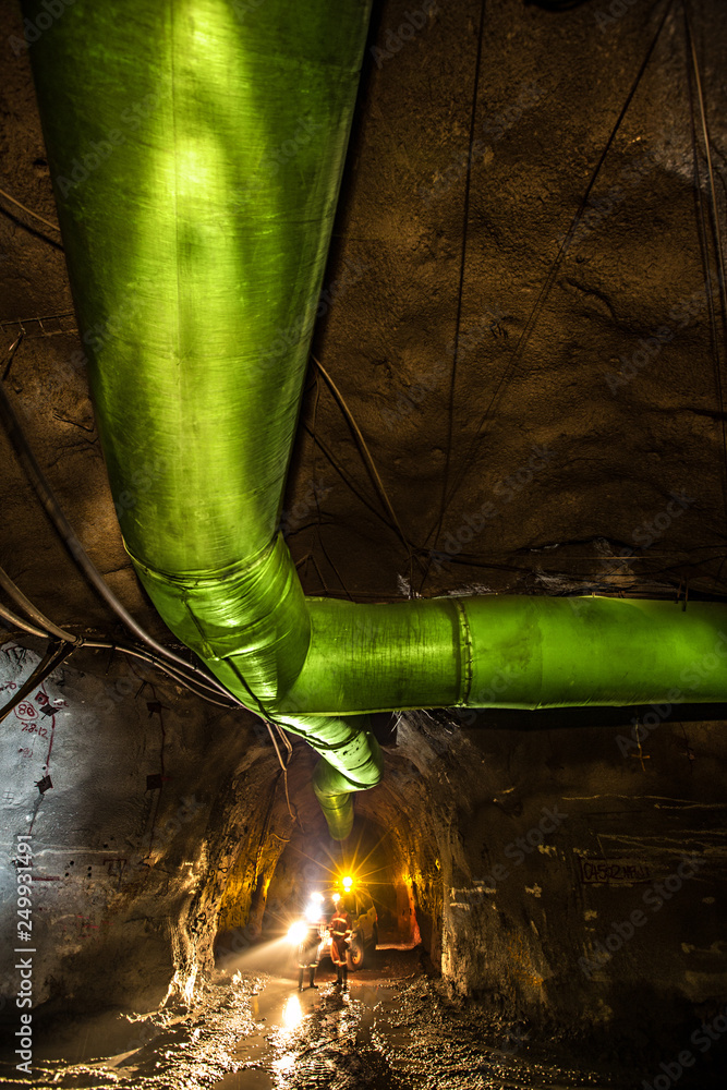 Miners inspecting an underground ventilation system in a gold mine in ...