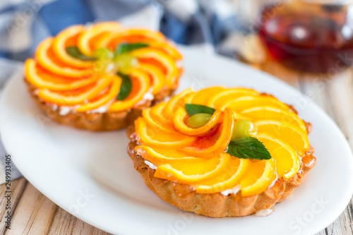 Delicious sugar dessert with citrus, orange and grapefriut with mint on white plate photo