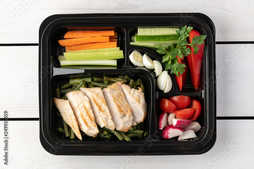 Healthy food to go in plastic bento lunchbox on wooden background. flat lay