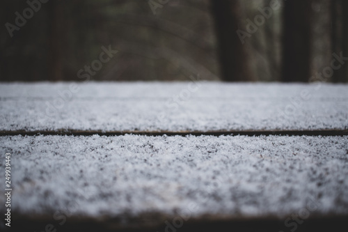 Closeup of snow flakes on a wooden bench