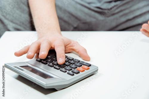 Using a calculator for counting. Man's hand clicks on buttons on the calculator, concept of counting money. Using a calculator to calculate.