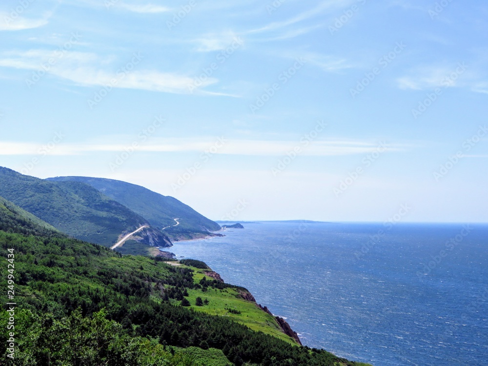 A distant view of the Cabot Trail on Cape Breton Island, Nova Scotia, Canada.  The beautiful coastal highway provides amazing views of the coastal landscape and vast Atlantic ocean.