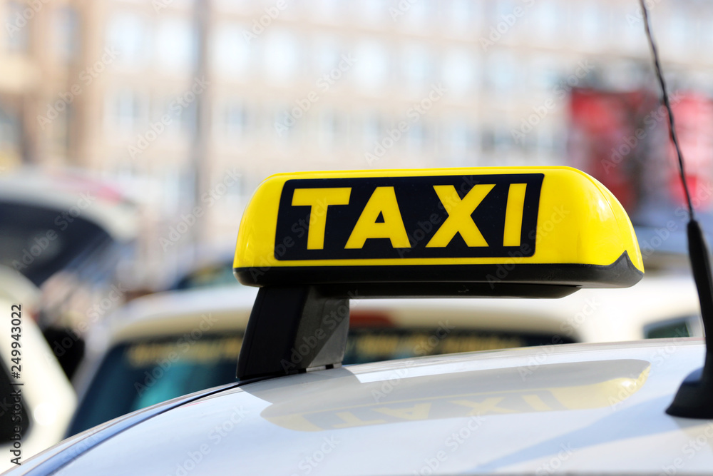 Day photo of a taxi car. Taxi sign on the car roof