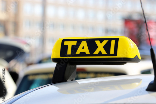 Day photo of a taxi car. Taxi sign on the car roof