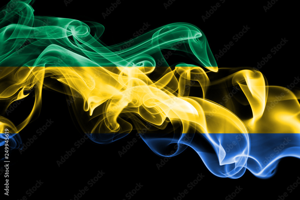 National flag of Gabon made from colored smoke isolated on black background. Abstract silky wave background.