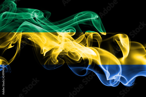 National flag of Gabon made from colored smoke isolated on black background. Abstract silky wave background.