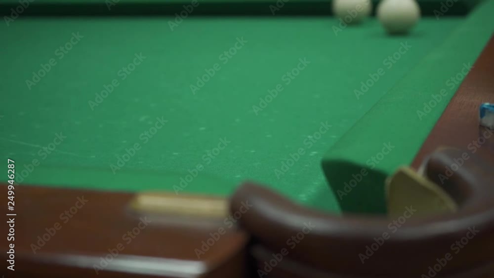 A man playing billiards on a green table hit a burgundy ball and scored white in a pocket