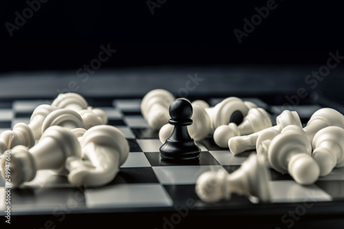 Chess board. Black pawn among the defeated white chess of the opponent