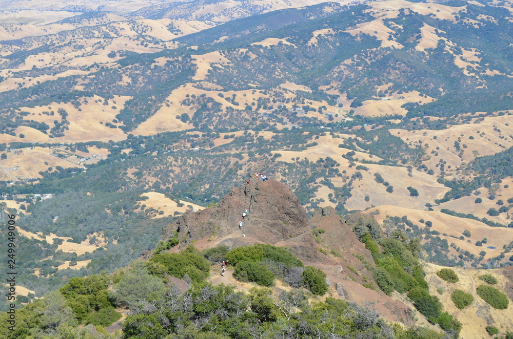 people climbing on top of a mountain