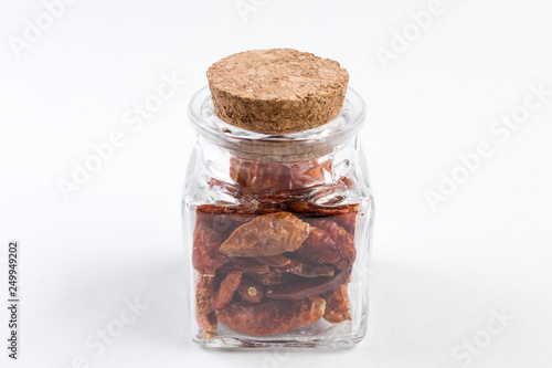 piri piri pepper in a glass jar isolated on white background