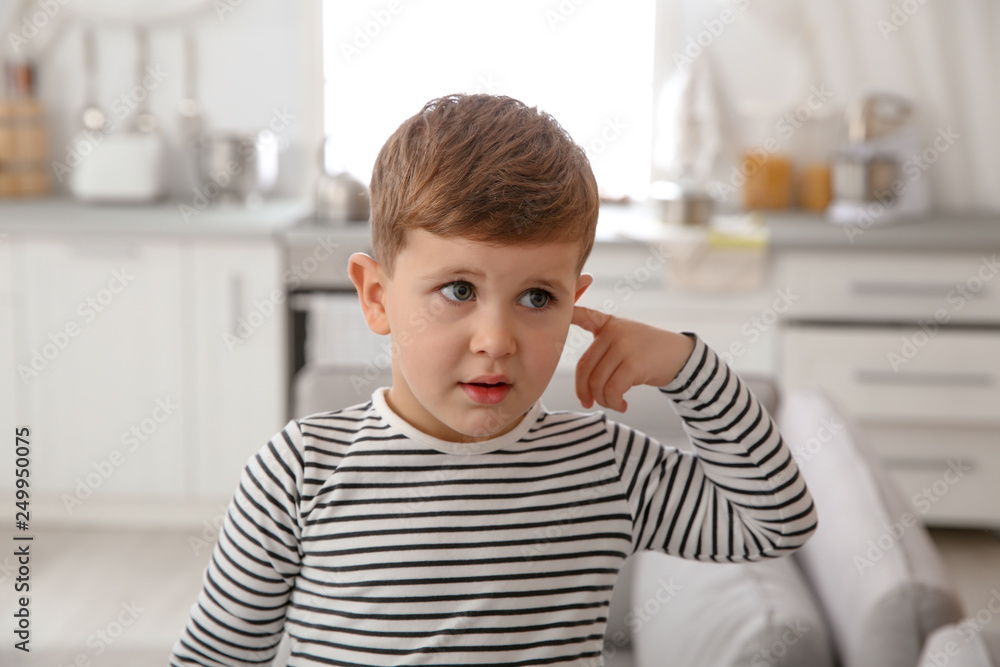 Little boy picking ear at home. Annoying itch Little boy picking ear at home. Annoying itch