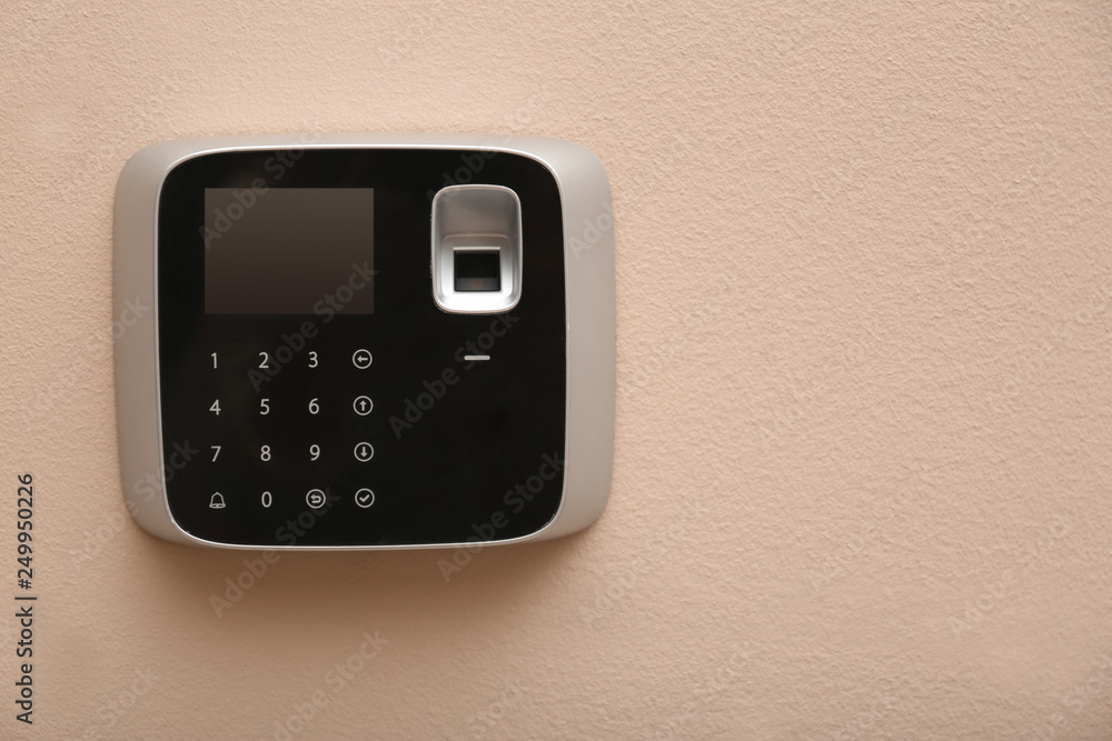 Modern alarm system with fingerprint scanner on color wall. Space for text Modern alarm system with fingerprint scanner on color wall. Space for text