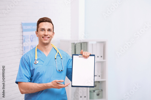 Portrait of medical assistant with stethoscope and clipboard in hospital. Space for text