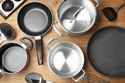 Flat lay composition with clean cookware on wooden background photo