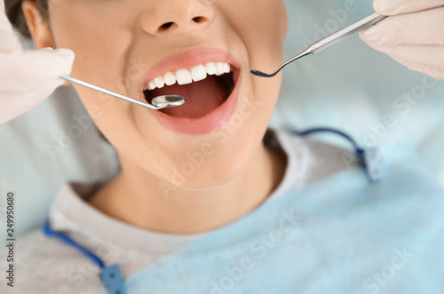 Dentist examining patient s teeth in modern clinic  closeup