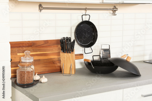 Set of clean cookware, utensils and products on table in modern kitchen photo