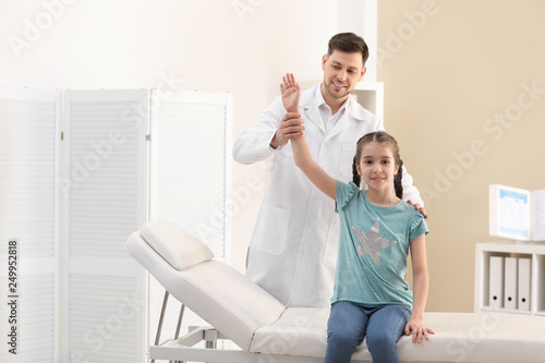 Chiropractor examining child with back pain in clinic