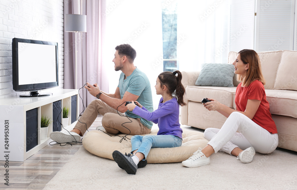 Happy family playing video games in living room Happy family playing video games in living room