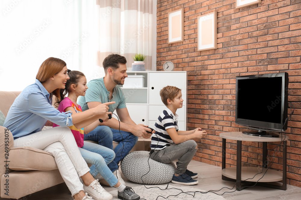 Happy family playing video games in living room Happy family playing video games in living room