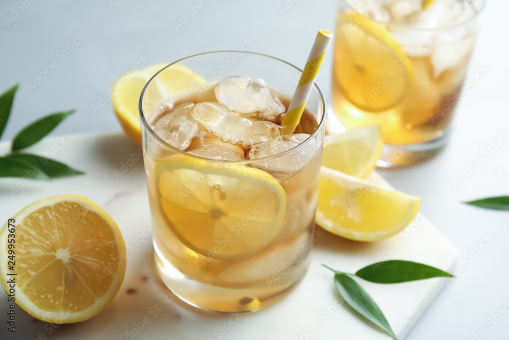 Glass of lemonade with ice cubes and fruit on table Glass of lemonade with ice cubes and fruit on table