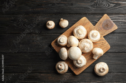 Flat lay composition with fresh champignon mushrooms on wooden table. Space for text