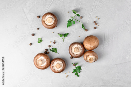 Flat lay composition with fresh champignon mushrooms on grey background