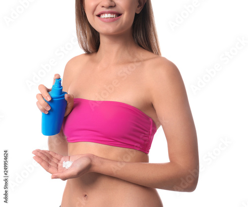 Woman applying sun protection cream on body against white background, closeup
