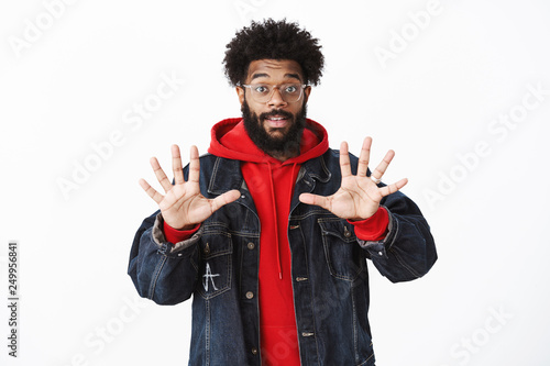 Portrait of pleased and friendly-looking african-american bearded male in glasses raising hands showing number ten or tenth, liftin eyebrows and smiling delighted, explaining how much he won photo