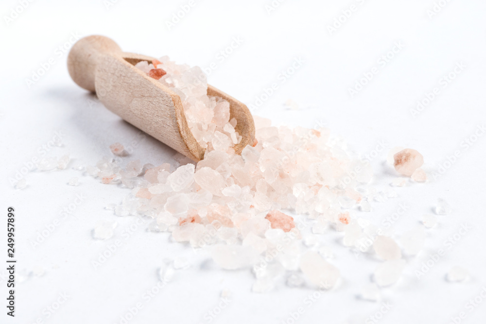 Himalayan pink salt in wooden scoop isolated on white background. Closeup. Himalayan pink salt in wooden scoop isolated on white background. Closeup.