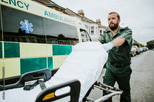 Male paramedic moving the ambulance stretcher photo