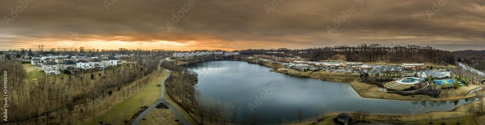 Aerial panorama of American luxury real estate neighborhood in Pikesville Maryland with single family houses, mansions, high quality buildings, condos, town houses and shop around a former quarry lake