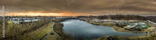 Aerial panorama of American luxury real estate neighborhood in Pikesville Maryland with single family houses, mansions, high quality buildings, condos, town houses and shop around a former quarry lake