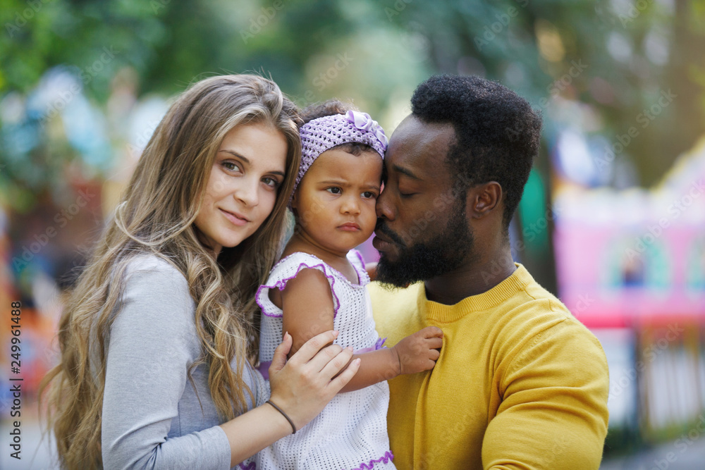 Pretty dark-skinned girl, father and mother in the park. Pretty dark-skinned girl, father and mother in the park.