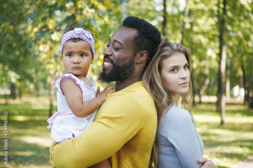 Pretty dark-skinned girl, father and mother in the park.