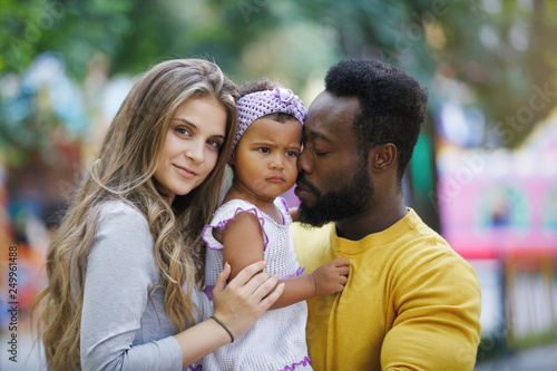 Pretty dark-skinned girl, father and mother in the park.