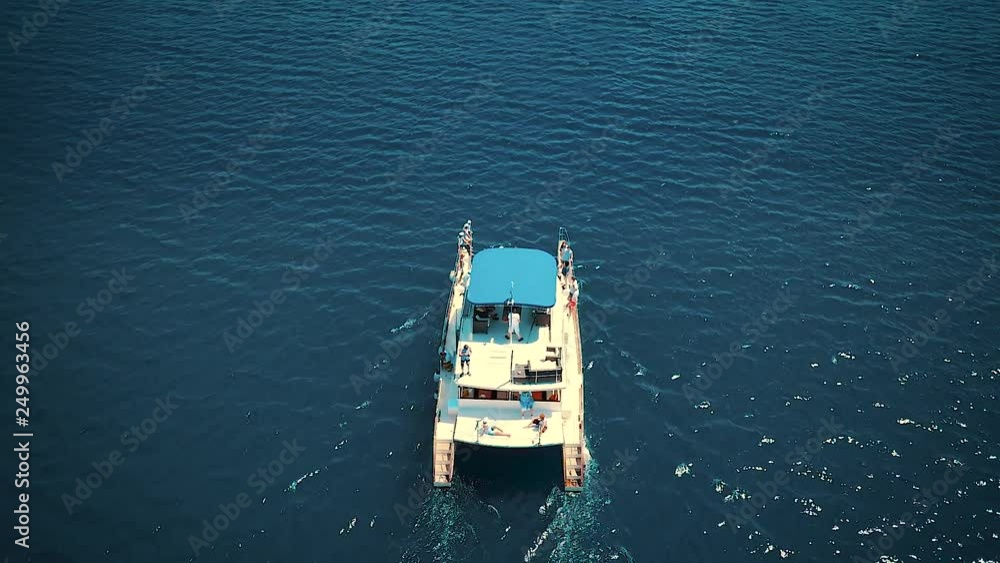 Aerial view following of the boat cruising with young people in the sea in Montenegro Aerial view following of the boat cruising with young people in the sea in Montenegro