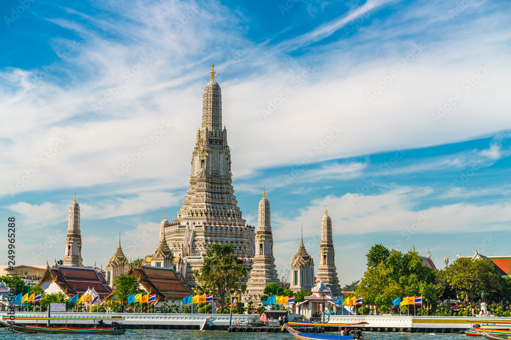 Fototapeta premium Temple of dawn Wat Arun with boat blue sky sunny day