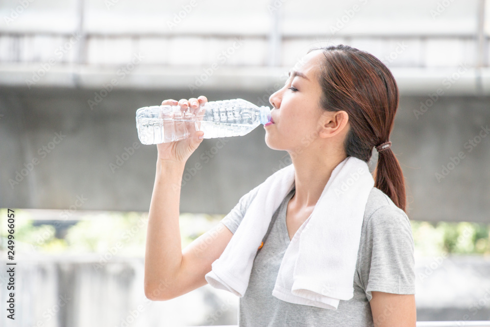 Asian sport woman is drinking bottle of water Asian sport woman is drinking bottle of water