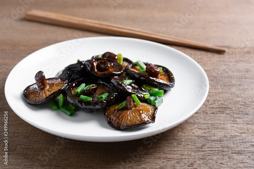 fried shiitake mushroom in a ceramic dish on wooden table. asian homemade style food concept.