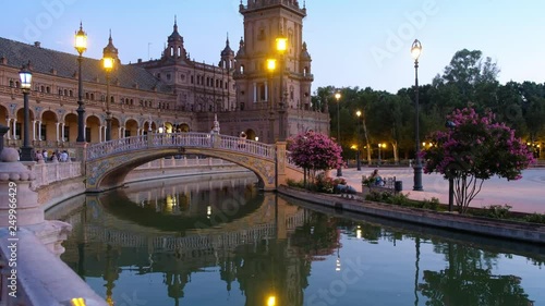 Night view of Spain Square (Plaza de Espana) with bridge reflecing in water of canal. Seville, Spain