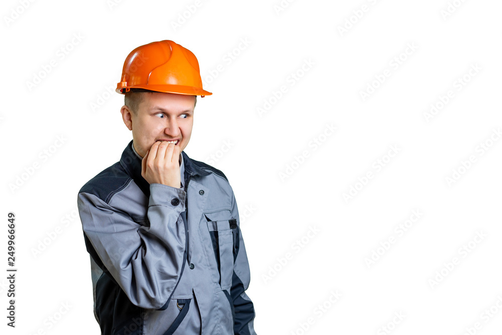A scared builder worker closes his mouth from fear. Isolated on white background. Construction mistake. A scared builder worker closes his mouth from fear. Isolated on white background. Construction mistake.
