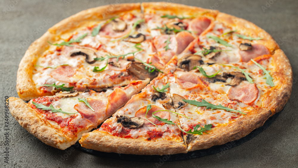 Delicious hot pizza with ham and champignons.