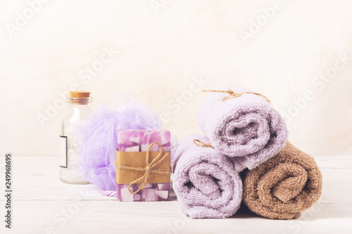 Set for spa treatments. Soft clean towels bath salt a piece of natural soap laid on a light background.