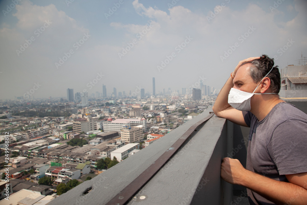 Portrait of man wearing facial hygienic mask outdoors. Ecology, air pollution, Environmental awareness and virus protection concept 