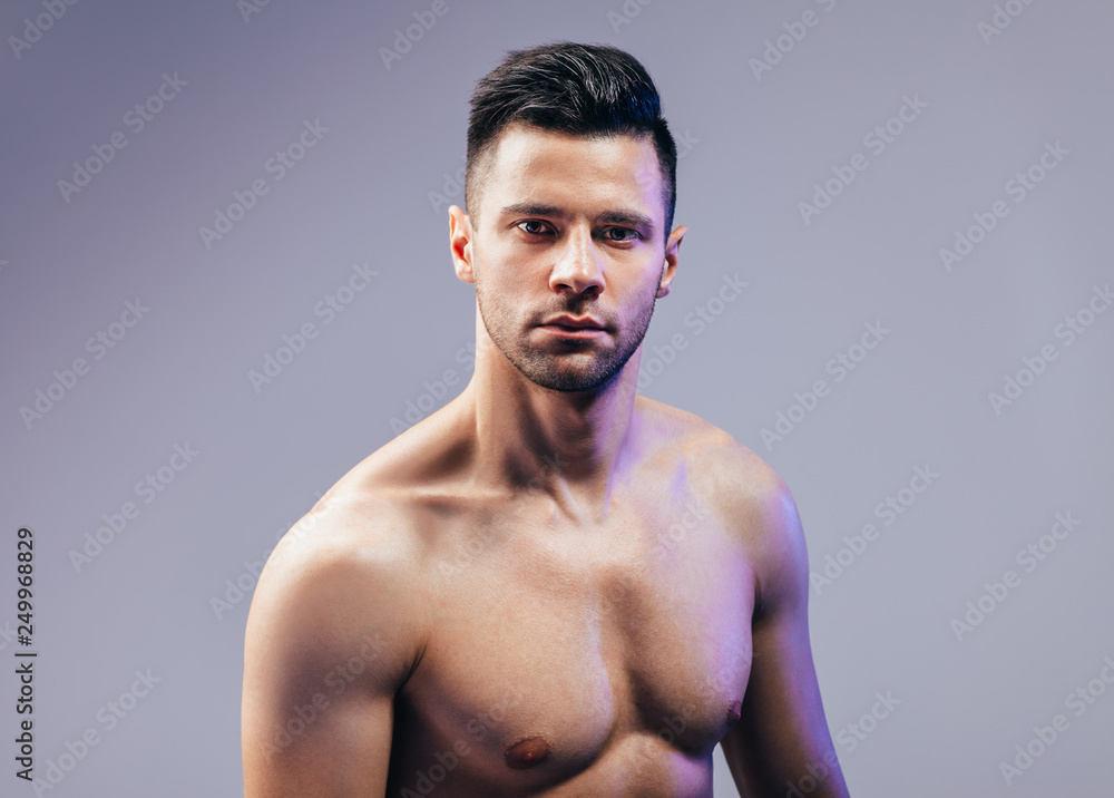 Naklejka premium Sexy muscular shirtless man posing in studio