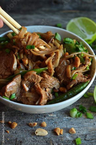 Rice noodles with pork in a white bowl. Asian dish in a bowl