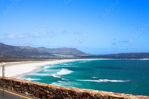 Seascape, turquoise ocean water waves, blue sky, white sand lonely beach panorama, bright sun, azure sea shore, summer vacation concept, beautiful nature mountains landscape, South Africa coast travel